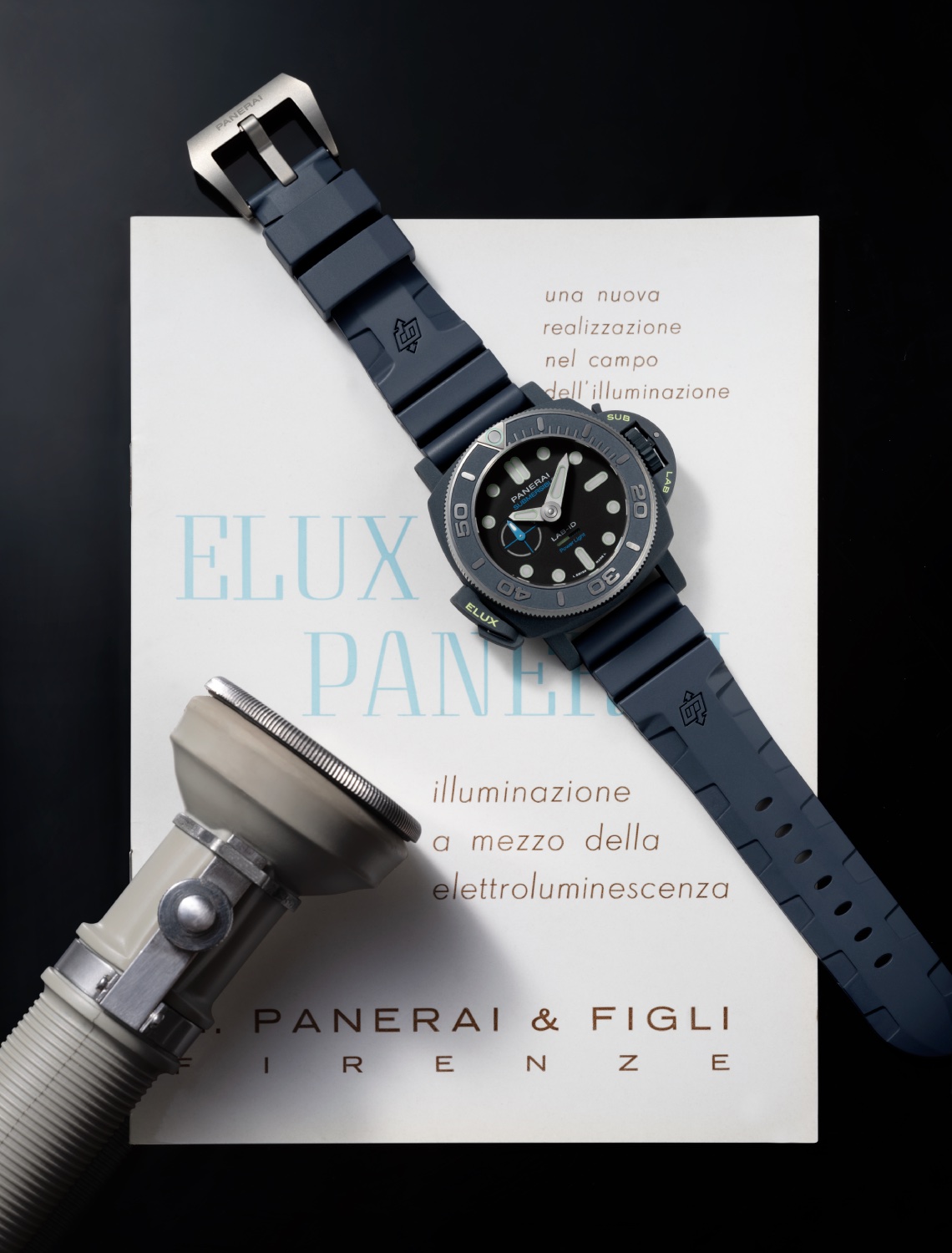 panerai submersible elux lab-id on a table with a flashlight beside it