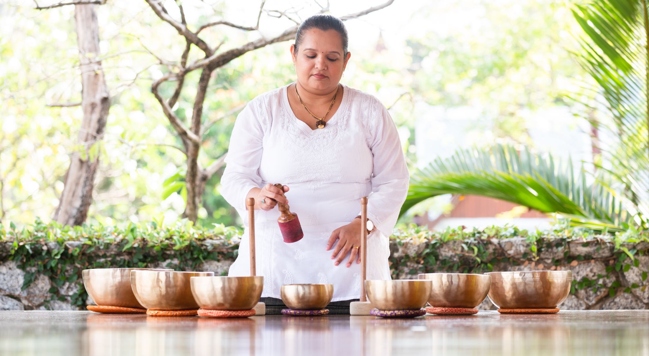 a lady with several singing bowls in front of her